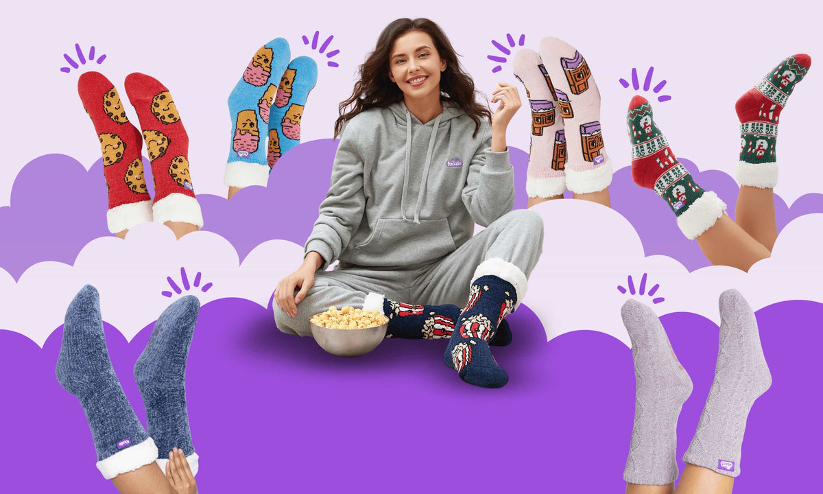 A woman in a grey hoodie with a bowl of popcorn, wearing The Foozie slipper socks