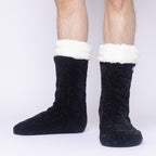 The Foozie™ in Black, front view of both feet worn by a man in Large with the sherpa cuffs folded down