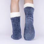 The Foozie™ in Blue, back view worn by a man in Large with one foot raised to show the non-slip grips on the sole